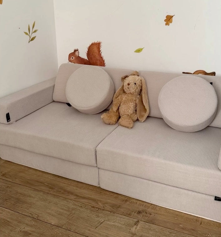 Le Canapé du Bonheur Tipichou placé dans un angle de pièce chez @lesminisboutchous, avec deux coussins ronds et un lapin en peluche. Partenariat, produit offert.